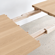 Close-up of a light natural wood table extension joinery detail.