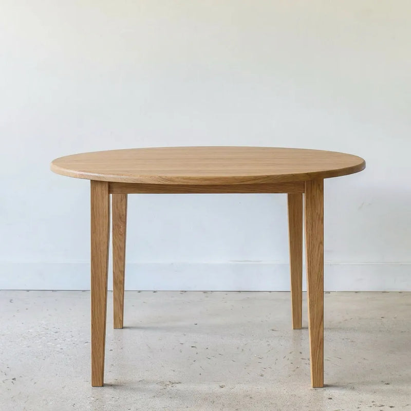 Round Tapered Leg Dining Table Pictured in White Oak Clear