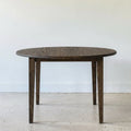 Round Tapered Leg Dining Table Pictured in White Oak Black