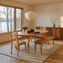 A warm, modern dining room featuring our Tapered Leg Oval Dining Table, <a href="https://wwmake.com/products/reclaimed-wood-dining-chairs-barnwood-dining-chairs"> Farmhouse Chairs </a>, <a href="https://wwmake.com/products/reclaimed-plank-bench-tapered-wood-legs"> Tapered Leg Wood Benches </a> and our <a href="https://wwmake.com/products/modern-prairie-storage-cabinet"> Modern Prairie Credenza.</a> 
