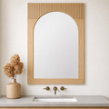 Bixby solid wood arched rectangular wall mirror with a light natural wood frame and vertical fluting at the top mounted above a bathroom vanity.