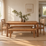 Our farmhouse solid wood dining table set in a bright, modern dining room with matching wood chairs and benches.