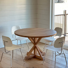 A lovely customer's home featuring  our Round Solid Wood Pedestal dining table, pictured in White Oak Natural, with four white chairs.
