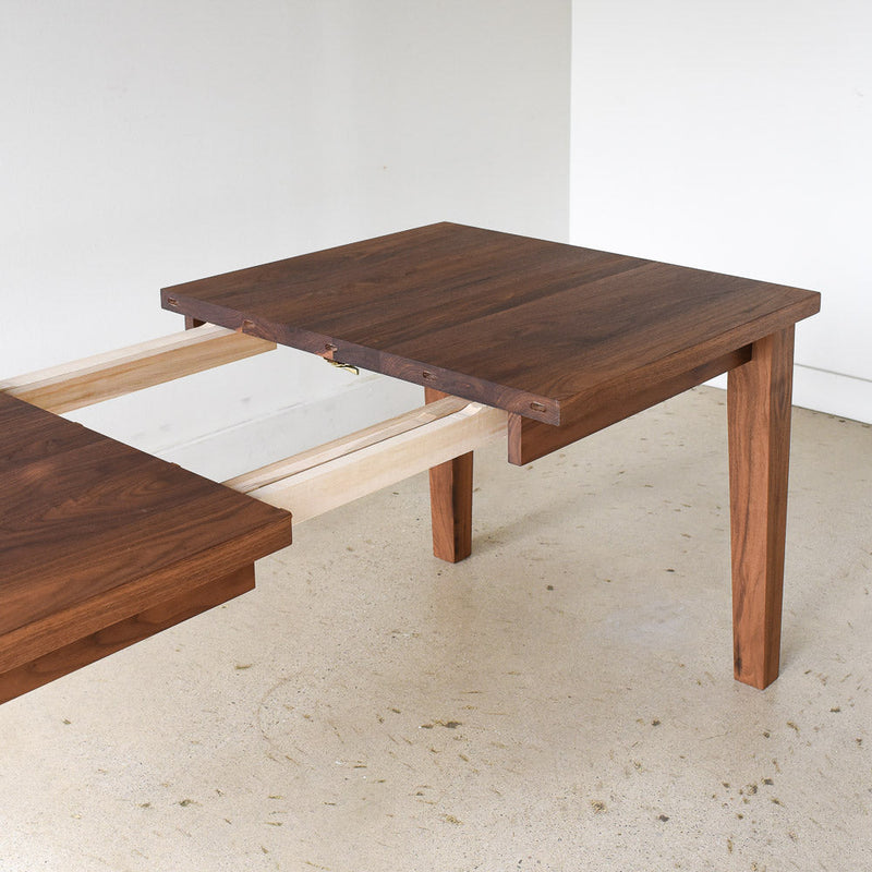 Extendable Tapered Leg Dining Table Pictured in Walnut Clear - Leaf Opening Detail