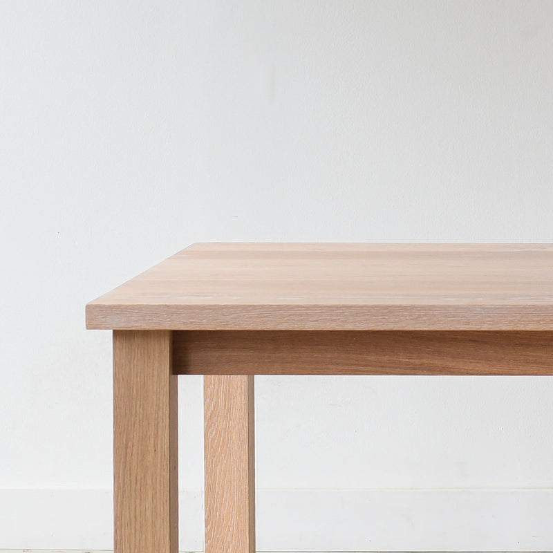 Close-up of solid wood plank table corner, Parsons style design.