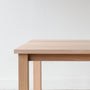 Close-up of solid wood plank table corner, Parsons style design.