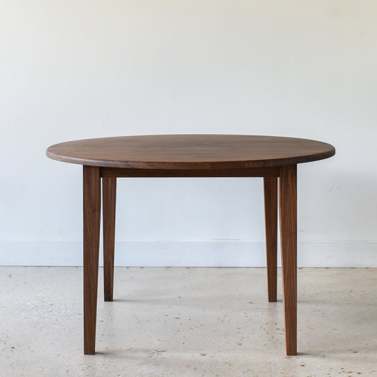 Round Tapered Leg Dining Table Pictured in Walnut/Clear