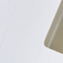 A close-up of soft white quartz countertop with subtle veining.