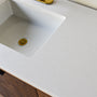 A close-up of soft white quartz countertop with subtle veining.