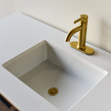 A modern white Kohler rectangular undermount sink set into the soft white quartz vanity top.