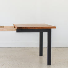 A close-up of a Industrial Plank Extendable Dining Table in Reclaimed Oak Clear &amp; Blackened Metal Base