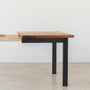 A close-up of a Industrial Plank Extendable Dining Table in Reclaimed Oak Clear &amp; Blackened Metal Base