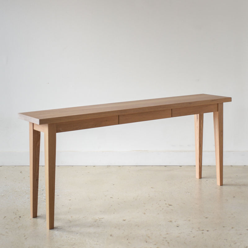 Tapered Leg Console Table With Hidden Drawer Pictured In White Oak Natural