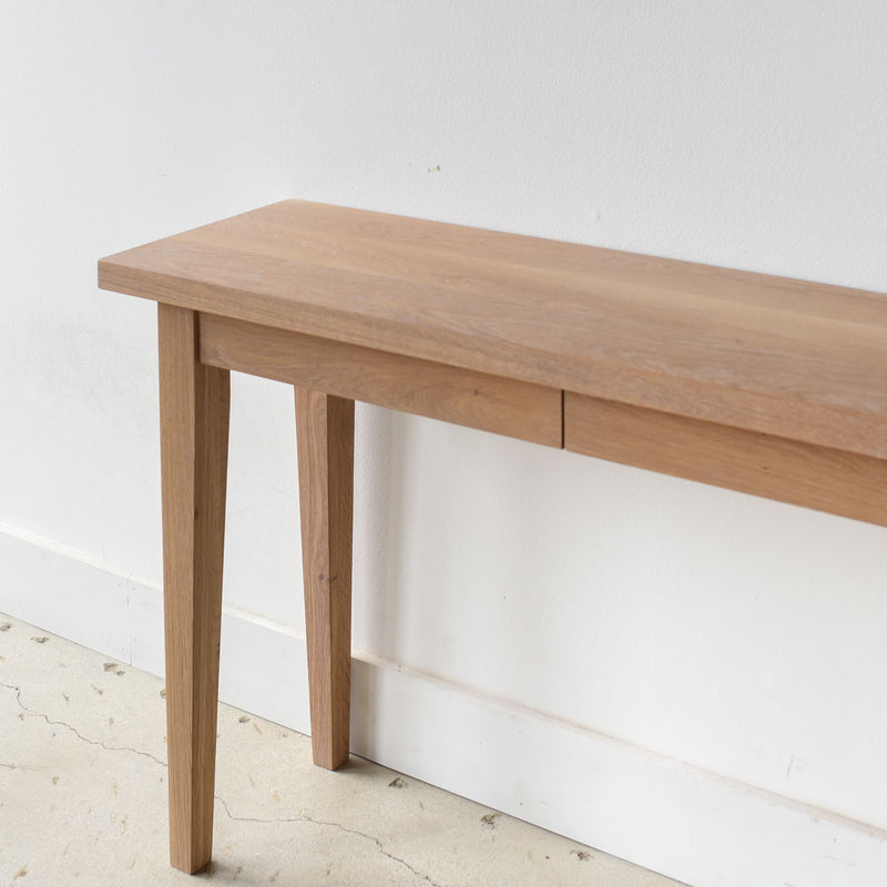 Tapered Leg Console Table With Hidden Drawer Pictured In White Oak Natural