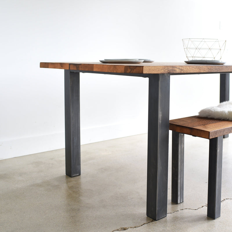 Post Leg Dining Table - Side view of blackened metal post legs &amp; &lt;a href=&quot;https://wwmake.com/products/industrial-modern-reclaimed-wood-bench-u-shaped-metal-legs&quot;&gt;Industrial Post Leg Bench&lt;/a&gt;